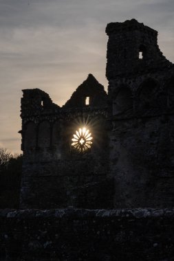 Pembrokeshire, Galler, Birleşik Krallık. St. David Katedrali 'ndeki Piskopos Sarayı' nın harabelerinin arkasında gün batımı..