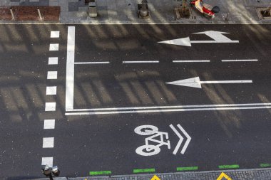 Madrid, İspanya - 02 Şubat 2026. Beyaz trafik okları ve bisiklet şeridi sembolü olan asfalt yolun tam üstünde.