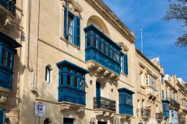 Valletta, Malta - 3 Şubat 2026: Canlı koyu mavi ahşap balkon içeren neoklasik kireç taşı bina