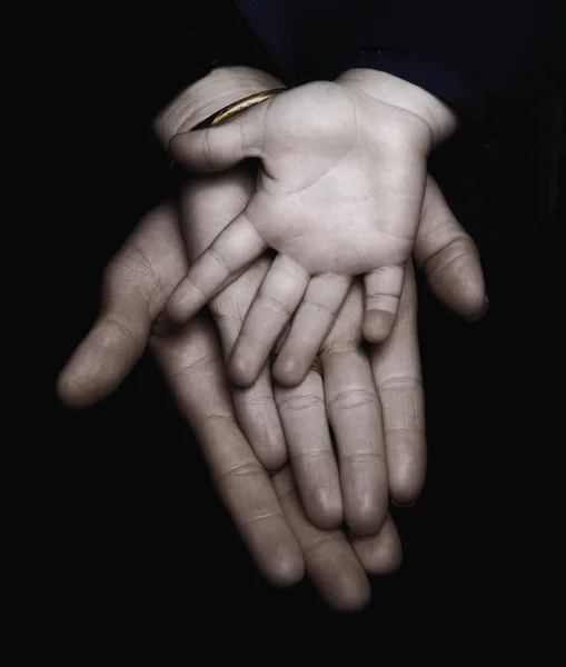Familia manos sobre fondo negro — Foto de Stock