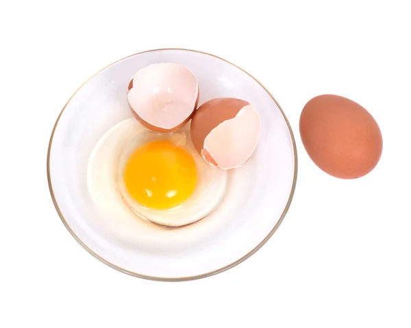 Cracked brown eggs on plate Stock Image
