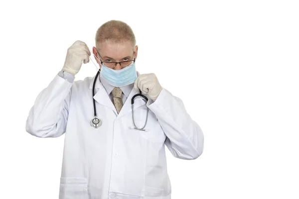 Доктор в латексних рукавичках одягає серйозну маску — стокове фото