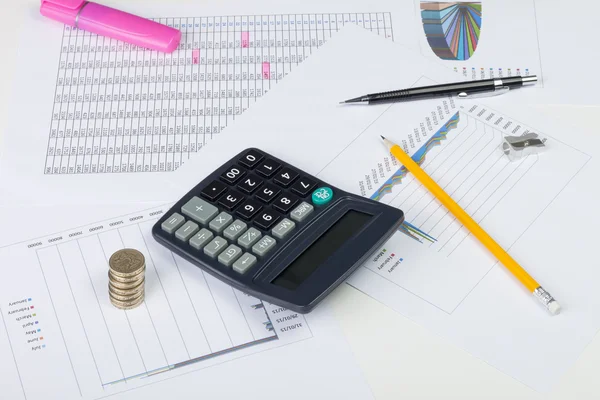 Busy financial desktop with calculator, money and charts — Φωτογραφία Αρχείου