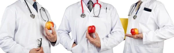 Three doctors wearing stethoscopes holding juicy apples — Zdjęcie stockowe