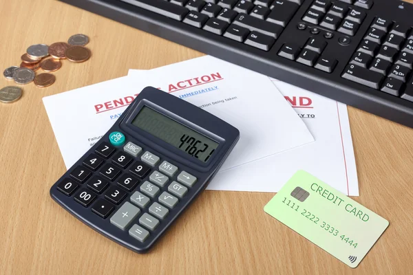Skrivbord som visar sista krav med kreditkort och miniräknare — Stockfoto