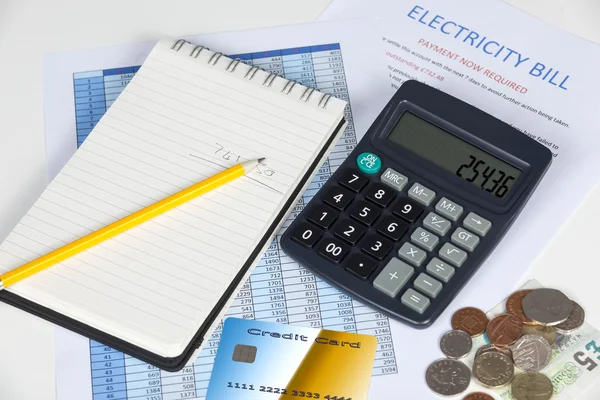 Escritorio mostrando una factura de electricidad atrasada con una calculadora —  Fotos de Stock