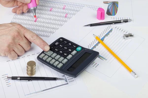 Bir satış defterini hesap makinesiyle dengeleyen muhasebeci