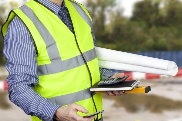 Building surveyor in high visibility carrying site plans — Stock Photo, Image