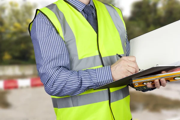 Building surveyor with sprit level writing notes in his folder — Stock Photo, Image