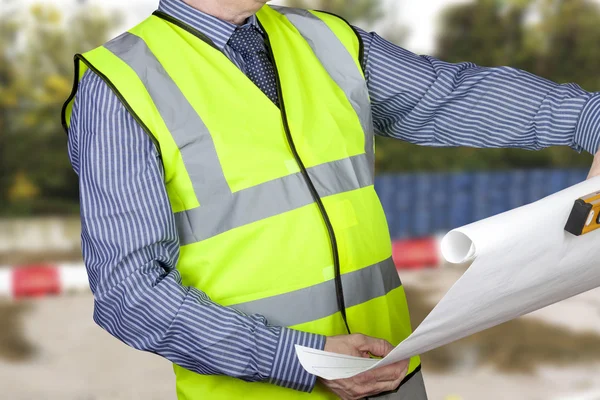 Building surveyor in high visibility checking site plans — Stock Photo, Image