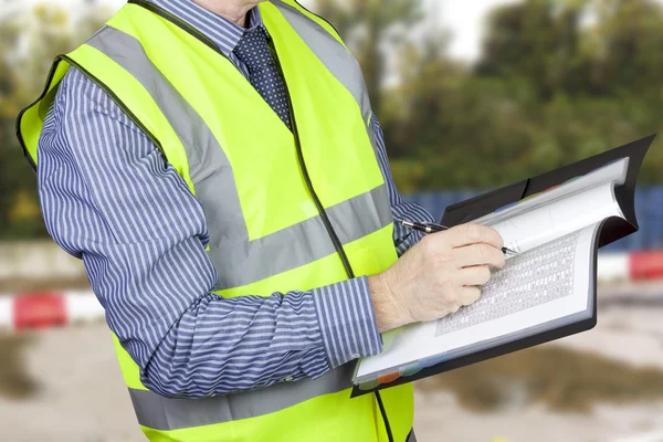 Building surveyor in high visibility checking data — Stock Photo, Image