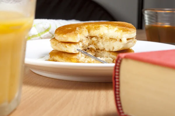 Stack of pancakes and syrup on a breakfast table Stock Image