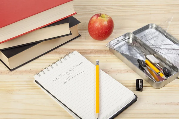 School desktop with notepad, books and pencil sharpener