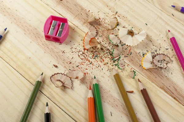 Sharpening colouring pencils on a wooden desk — Stock Photo, Image