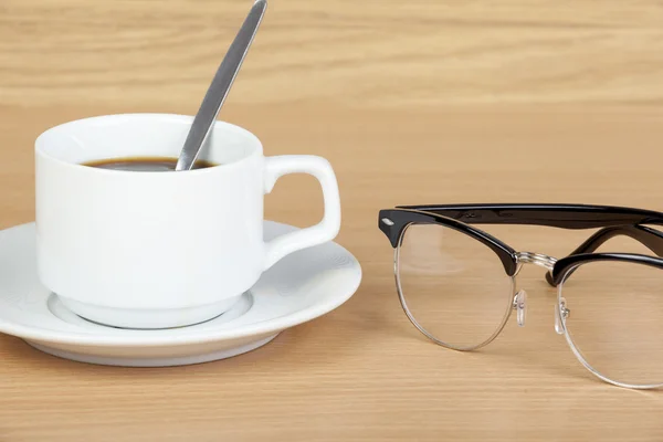 Copa de café negro en la mesa con gafas para los ojos —  Fotos de Stock