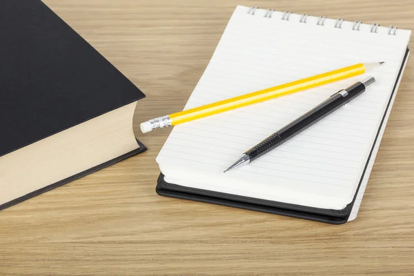 Pen and pencil on a notepad on a desk — Stock Photo, Image