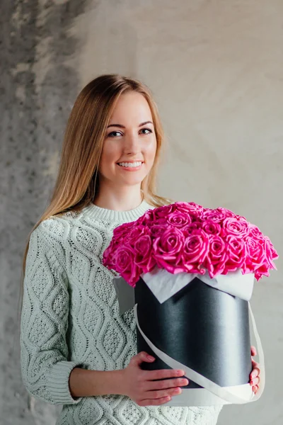 Lächelndes Mädchen mit einem Strauß rosa Rosen — Stockfoto