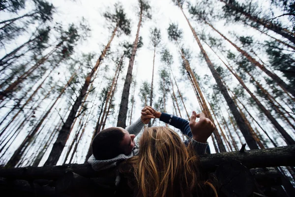 Loving couple lying on the flooring in the forest — Stock Photo, Image