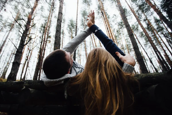 Loving couple lying on the flooring in the forest — Stock Photo, Image