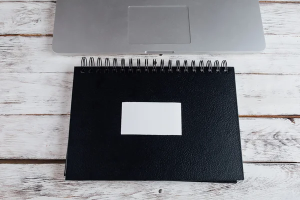 Fekete spirál jegyzetfüzet, laptop közelében — Stock Fotó