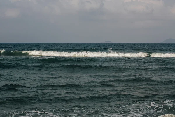 Волны возле береговой пены — стоковое фото