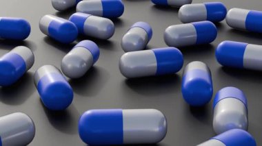 3D animasyon, karanlık bir yüzeye dağılmış mavi ve beyaz kapsüllerden oluşan bir koleksiyonu gösteriyor. Bu da ilaç veya sağlıkla ilgili içeriği gösteriyor.