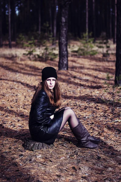 A menina em um casaco de couro preto e um chapéu preto de pé, segure — Fotografia de Stock