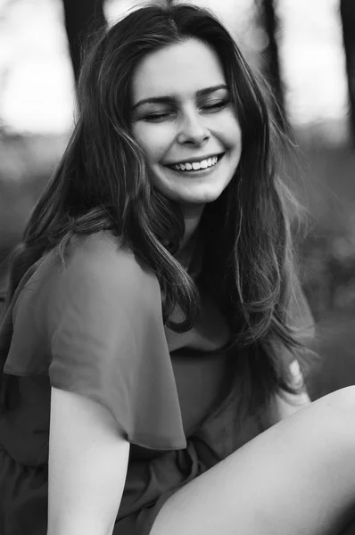 Menina bonita nova em um casaco rosa e botas de vestido curto rosa descansando em um prado verde de primavera em um fundo de grama verde. Mulher bonita ao ar livre. Desfrute da natureza . — Fotografia de Stock