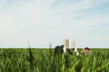 Dışarıda yatan ve kitap okuyan biri. Sevimli genç kadın sitti