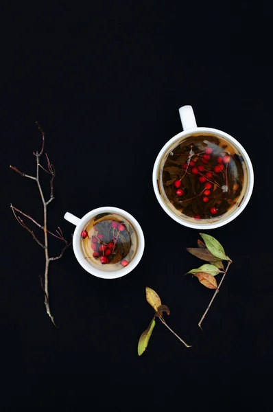 Чашки свежего травяного чая на черном столе. Чашка зеленого травяного чая — стоковое фото