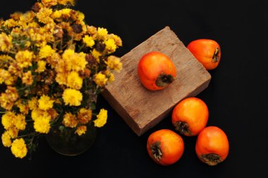 Persimmonon siyah arka plan. Taze organik Trabzon hurması. Başına taze