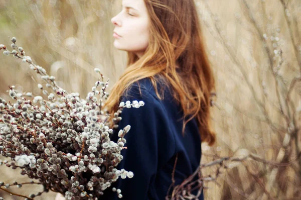 Portrait of a beautiful young girl with a huge armful of willow — Stock Photo, Image