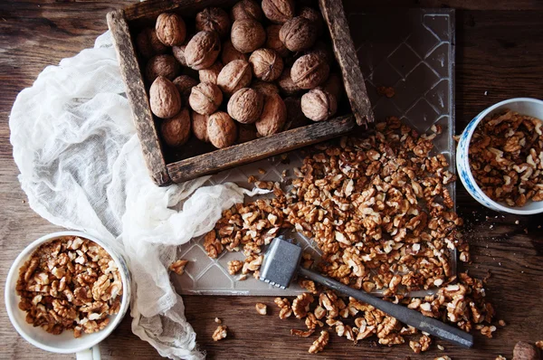 Ядра грецкого ореха и целые грецкие орехи на деревенском деревянном столе. Кто — стоковое фото