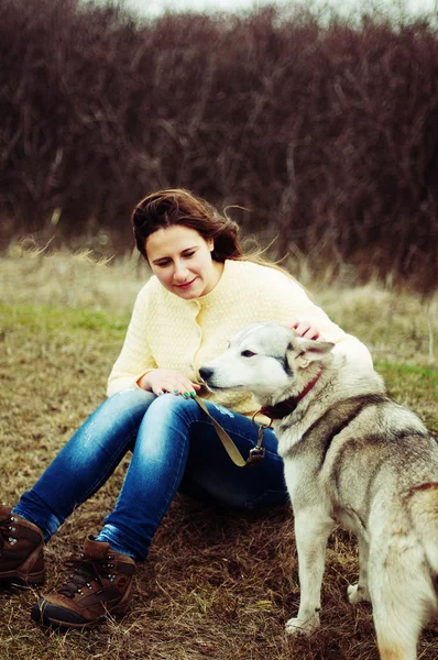 Dívka v parku svůj domov s pes Husky. Dívka s — Stock fotografie