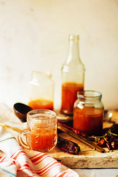 Salsa piccante di peperoncino rosso su vecchio sfondo di legno bianco. Rus '. — Foto Stock