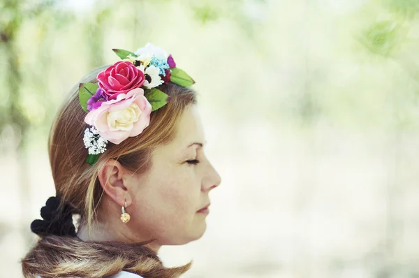 Mladá krásná žena pózuje v 40 Krásný květinový věnec na mu — Stock fotografie