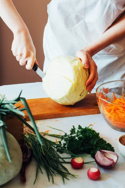 Woman on kitchen cuts vegetables for salad. Dieting and detox dr