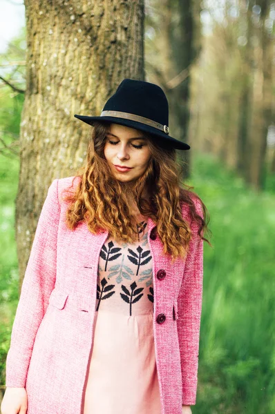 Портрет молодой элегантной женщины в розовом пальто и черной шляпе. Мода — стоковое фото