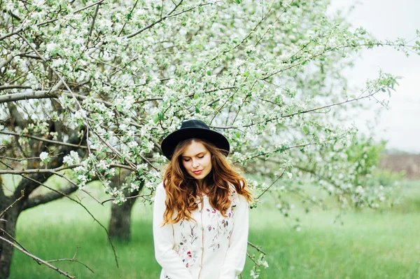 Retrato de moda ao ar livre de senhora elegante em pé perto de bicicleta hipster em vestido rosa elegante. Aproveite e divirta-se dia de primavera no parque com um filtros vsco. Menina bonita com cabelo ondulado grosso longo — Fotografia de Stock