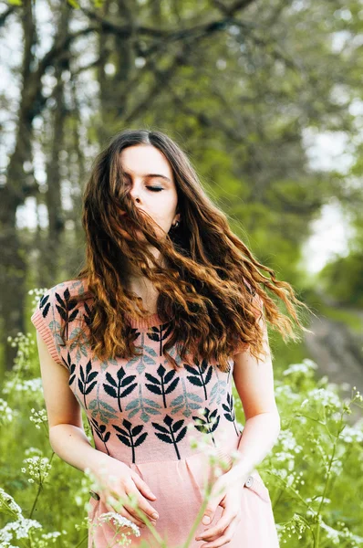 Outdoor fashion portrait of elegant lady standing near hipster bicycle in pink stylish dress. Enjoy and having fun spring day in the park with a vsco filters. Beautiful  girl with long thick wavy hair — Stock Photo, Image