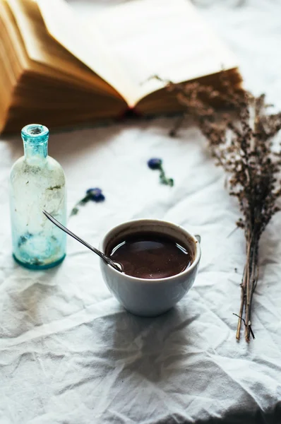 Café caliente fresco en una pila de libros sobre una mesa cubierta con un wh — Foto de Stock