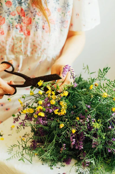Indah karangan bunga ungu dan kuning liar di lampu kamar di atas meja putih . — Stok Foto