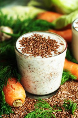 Bardak yoğurt ile beyaz bir arka plan üzerinde ezilmiş keten tohumu. 