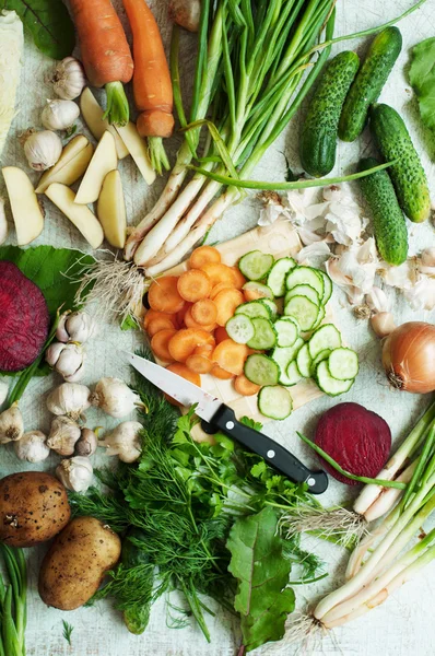 Vegetales anaranjados y verdes y composición de raíces en una pizarra oscura t — Foto de Stock