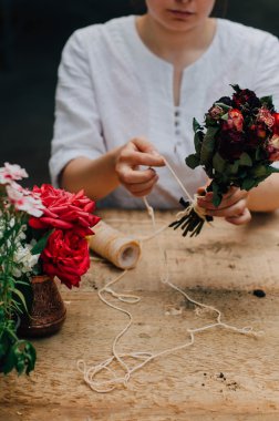 Bir tablo rustik, Bahçe işi bahçıvan. Bahçede çalışan, bir kadın bakımları flowerscarnations el ile kapatın. Kadının elleri. Çiçekli Bahçe aletleri.