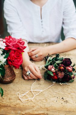 Bir tablo rustik, Bahçe işi bahçıvan. Bahçede çalışan, bir kadın bakımları flowerscarnations el ile kapatın. Kadının elleri. Çiçekli Bahçe aletleri.
