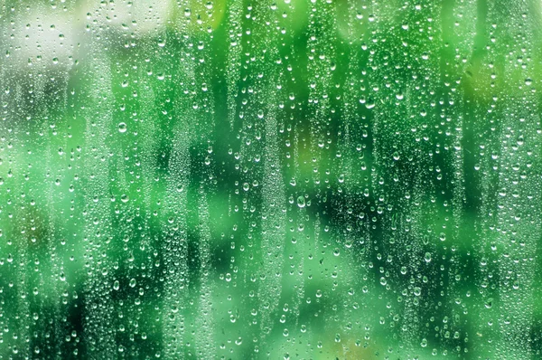 Капли дождя на стекло окна. Через окно вид на g — стоковое фото