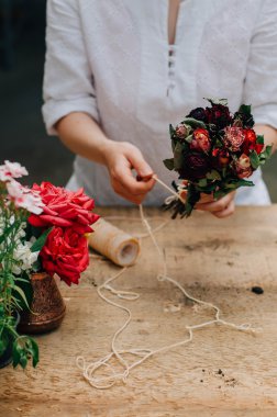 Bir tablo rustik, Bahçe işi bahçıvan. Bahçede çalışan, bir kadın bakımları flowerscarnations el ile kapatın. Kadının elleri. Çiçekli Bahçe aletleri.