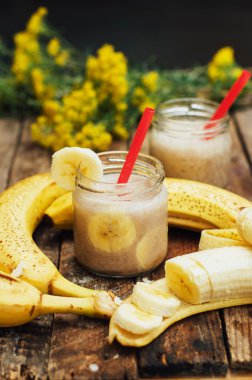 Meyve Smoothies. muz smoothies süt ile. Ahşap bir masa üzerinde Muz Smoothie. Sağlıklı Kahvaltı: muz smoothie yulaf ezmesi ile. Muz smoothie cam ahşap zemin üzerine taze meyve ile