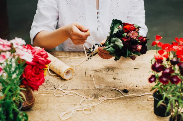 Bir tablo rustik, Bahçe işi bahçıvan. Bahçede çalışan, bir kadın bakımları flowerscarnations el ile kapatın. Kadının elleri. Çiçekli Bahçe aletleri.